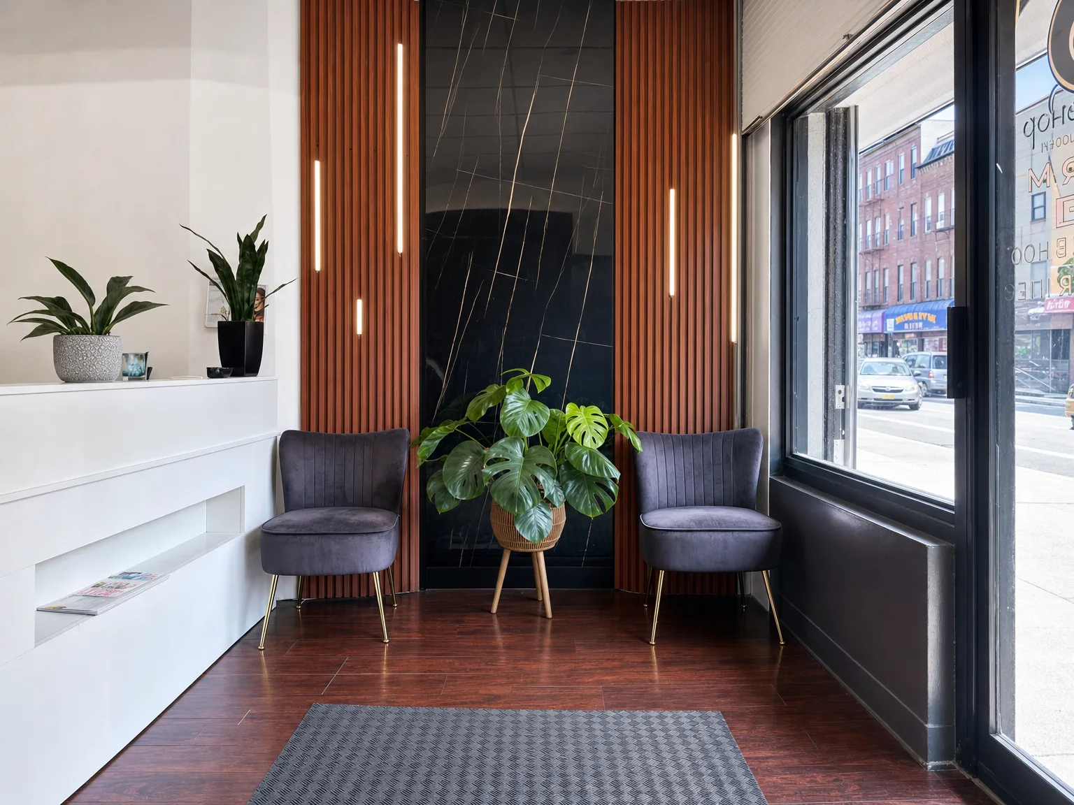 Waiting corner — velvet chairs and monstera against black marble